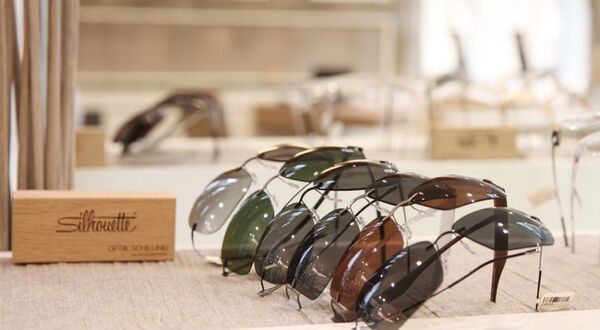 Verschiedene moderne Silhouette Sonnenbrillen bei Optiker auf heller Ausstellungsfläche.